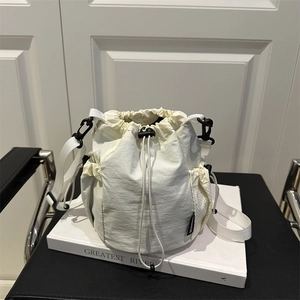 Sac seau minimaliste en nylon crème avec cordon de serrage, poche filet et sangle