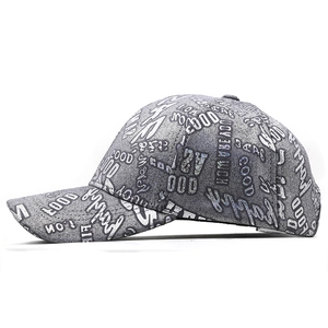 Detail view of grey baseball cap with graffiti style lettering and metallic fabric texture