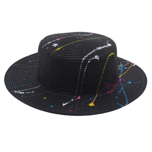 Detailed top view of black flat top straw hat featuring creative colorful paint splatters