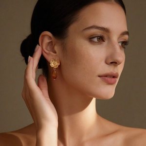 Vintage gold flower and amber resin teardrop earrings on a female model