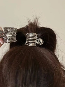 Detail of silver spiral metal hair claw clip showing both hand-held view and ponytail use