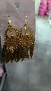 Detail of golden bohemian water drop tassel earrings on a white fashion jewelry card