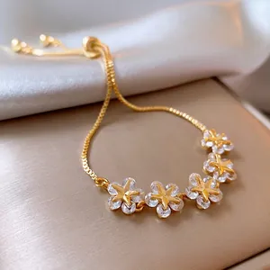 Gold plated snake chain bracelet featuring crystal star-centered flowers with ball clasp