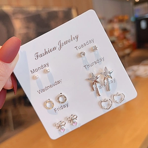 Close-up of 6 pairs silver stud earrings set featuring pearls and stars on Monday-Saturday card