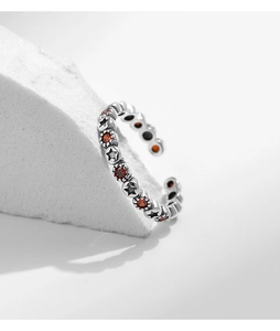 Gros plan d'une bague étoile en argent S925 avec gemme rouge et anneau texturé