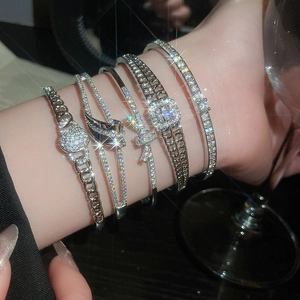 Gros plan de bracelets en argent sertis de zircons aux motifs géométriques et nœuds