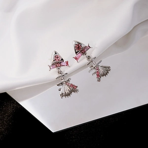 Detail of silver drop earrings featuring pink zircons on a white silk background