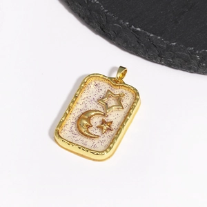 Detailed macro view of a gold rectangular pendant with purple glitter and star moon motifs