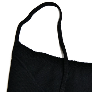 Gros plan détaillé sur la texture du tricot noir et la bretelle de la robe nuisette