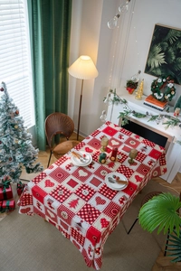 Close-up of festive red Christmas tablecloth with plaid patterns and heart decorations