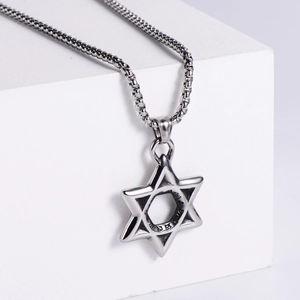 Modern stainless steel Star of David pendant necklace on a geometric display stand