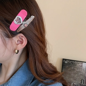 Close-up of Y2K style pink heart hair clip with rhinestones and champagne butterfly pin
