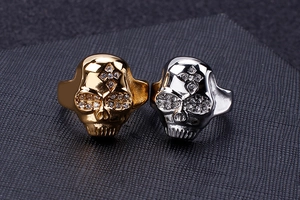 Macro detail of gold and silver hip hop skull rings with sparkling crystal eyes