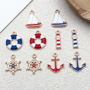 Detail view of 10 nautical enamel pendants featuring anchor lighthouse and sailboat charms