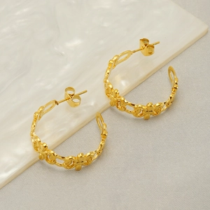 Detailed macro shot of vintage gold C-shape hoop earrings with chain link design