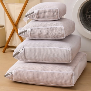 Set of 4 white honeycomb mesh laundry bags in various sizes for washing machines