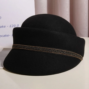 Elegant black wool newsboy hat featuring a decorative gold-trimmed band for women
