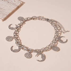 Detail view of double-layered silver necklace with bohemian sun and moon celestial pendants