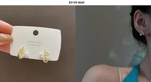Detailed view of leaf-shaped pearl earrings with gold base and 925 silver needles