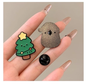 Gros plan sur la broche sapin de Noël en émail vert avec étoile et fermoir en caoutchouc