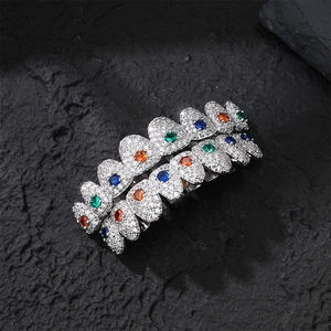 Hip hop silver grillz set with colorful stones and white zircons on black stone background