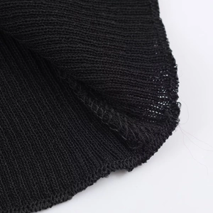 Close-up of black knitted fabric showing fine texture and professional overlock stitching