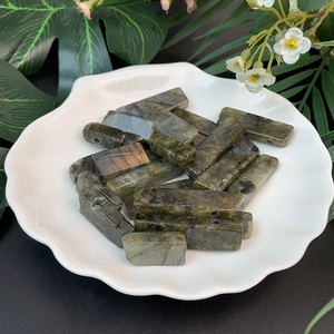 Macro view of rectangular labradorite stones with natural flash in a white ceramic dish