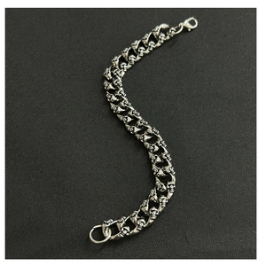 Silver skull link bracelet for men with dragon bone chain style on black background