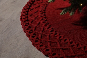 Vue détaillée du motif en tricot bordeaux et de la maille torsadée sur la jupe de sapin