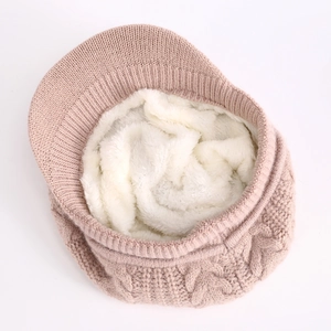 Primer plano del forro polar blanco suave dentro de una gorra de punto trenzado rosa