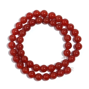 Close-up of polished red agate round beads for DIY jewelry making on white background