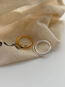 Close-up of gold and silver S925 sterling silver double layer rings on linen fabric