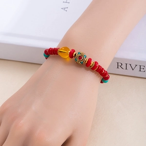 Gros plan d'un bracelet de perles bohème avec breloques tribales colorées sur le poignet