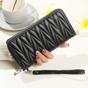 Macro shot of black V-quilted faux leather wallet with wristlet and metallic zipper