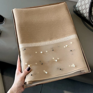 Detailed view of camel faux silk scarf featuring beaded pearls and silver glitter trim