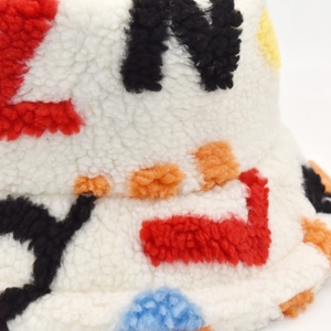 White faux shearling bucket hat with colorful embroidered letters for winter warmth