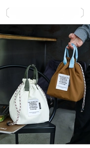 Close-up of insulated canvas lunch bag showing drawstring closure and wide handle