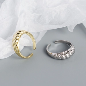 Detail of twisted croissant rings in gold and silver finish with adjustable open bands