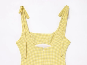 Detail view of yellow plaid dress showing square neck, bow straps and back zipper