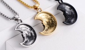Macro detail showing three colors of crescent moon pendants with textured metal finish