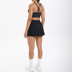 Détail de la brassière à dos croisé et jupe courte plissée en tissu technique noir