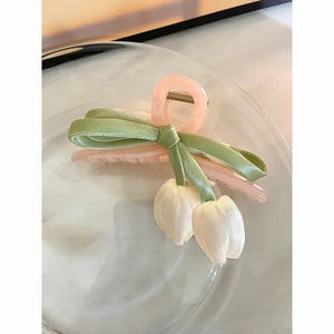 Detail of fabric tulip floral hair claw clip with elegant silk bow and resin finish