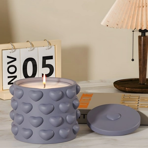 Lavender heart embossed scented candle jar with matching lid in a cozy home setting