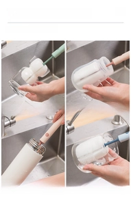 Detail of long handle sponge brush cleaning various cups in a kitchen sink setting