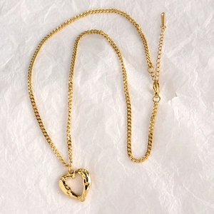 Golden heart pendant necklace with lava texture on flat chain with extension