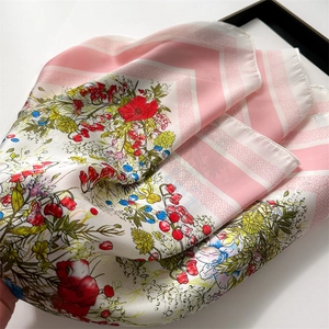 Detailed close-up of a floral silk square scarf with colorful wildflower patterns