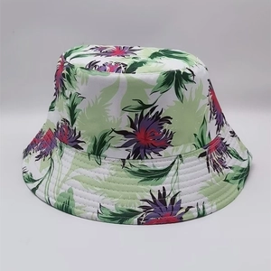 Detail of double-sided bucket hat featuring tropical floral and leaf patterns on white background
