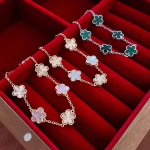 Elegant gold plated clover bracelet with mother of pearl and malachite clover charms