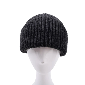 Close-up of thick dark grey knit beanie texture showing detailed warm ribbing pattern