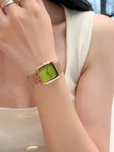 Close-up of elegant rose gold square watch with a green dial on woman's wrist